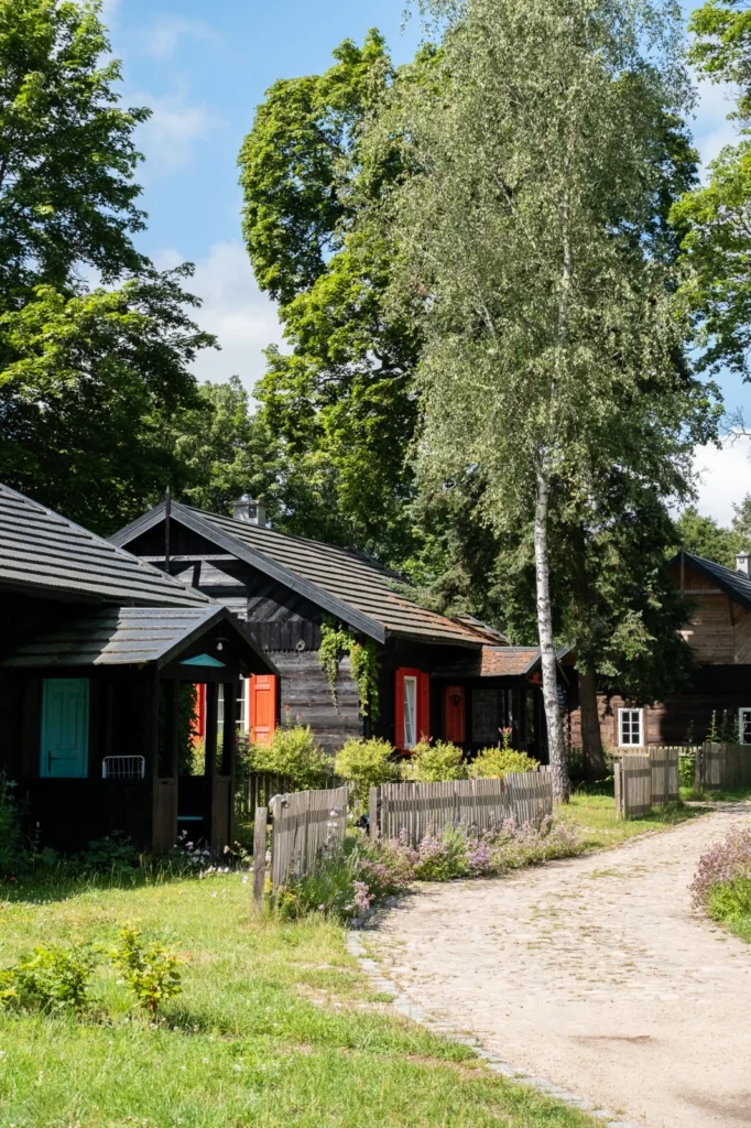 Drewniane domy wypoczynkowe Przysiółka Spore w otoczeniu zieleni.